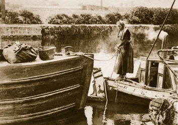 En kvinde, der sikrer agterstavnen på sin pram, London (sepia-billede)